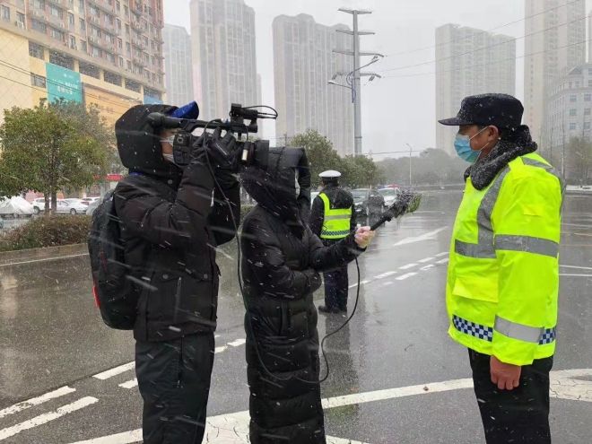 孝感市融媒體中心楊亞玲（風(fēng)雪中，采訪疫情期間重返一線的退休警察）_副本.jpg.jpg